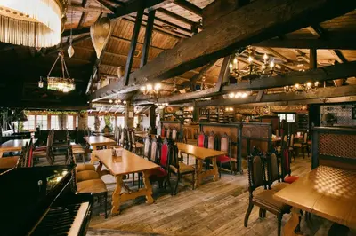 a restaurant with tables and chairs and a piano at La Moncloa de San Lazaro in Cacabelos