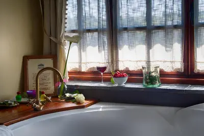 a kitchen sink with a window with two glasses of wine at La Moncloa de San Lazaro in Cacabelos