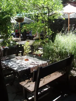 a table and a bench in a garden at La Moncloa de San Lazaro in Cacabelos
