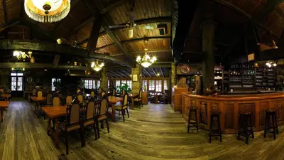 a restaurant with wooden tables and chairs and a bar at La Moncloa de San Lazaro in Cacabelos