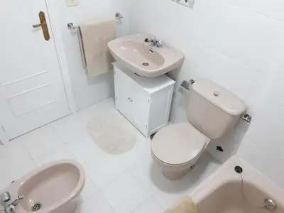 a white bathroom with a toilet and a sink at Piso Camino de Santiago 2 in Sarria