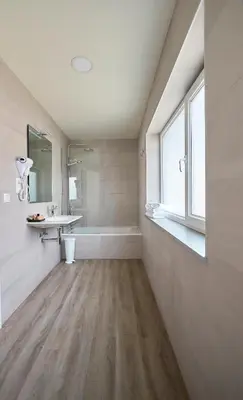 a bathroom with a tub and a sink and a bath tubermott at Hotel Boa Vista in Viveiro