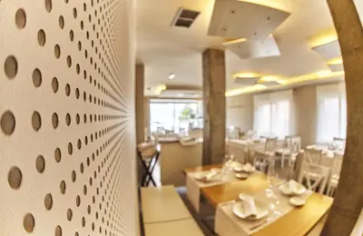 a restaurant with tables and chairs in a room at Hotel Boa Vista in Viveiro