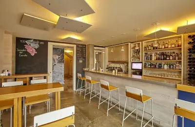 a restaurant with a bar with yellow chairs at Hotel Boa Vista in Viveiro