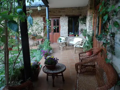 a patio with chairs and a table with flowers at La Casa del Filandón- HOTEL RURAL in Quintanilla de Somoza