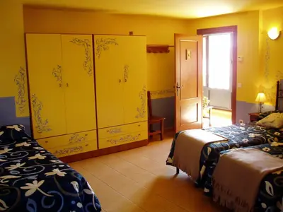 a bedroom with two beds and a large closet at La Casa del Filandón- HOTEL RURAL in Quintanilla de Somoza