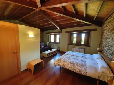 a bedroom with a bed and a couch in a room at Rectoral De Lestedo in Palas de Rei