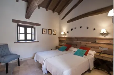a bedroom with two beds and a blue chair at Via Avis in Santa Catalina de Somoza