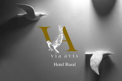 two birds are flying next to a hotel symbol at Via Avis in Santa Catalina de Somoza