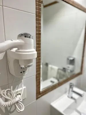 a bathroom with a hair dryer and a mirror at Hostal LA POETISA - Auto Check-in in Culleredo