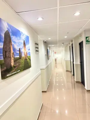 a hallway in a hospital with paintings on the walls at Hostal LA POETISA - Auto Check-in in Culleredo