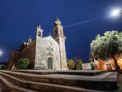 an old church with a clock tower at night at Outeiro de Setecamiños in Cuntis