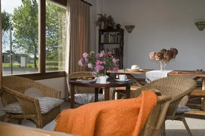 a dining room with a table with flowers on it at Apartamentos La Cruz de Paderne in Navia