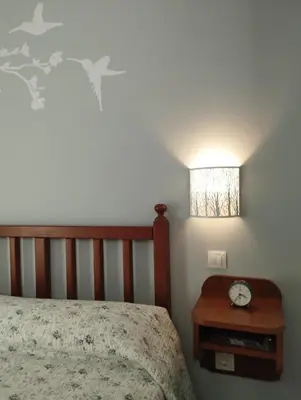 a bedroom with a bed and a clock on a night stand at Apartamentos La Cruz de Paderne in Navia