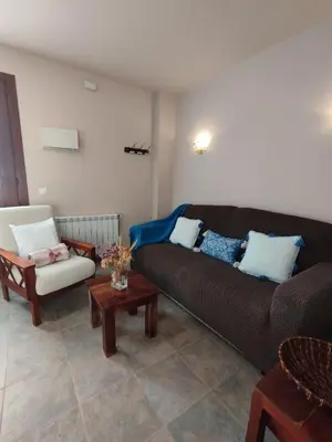 a living room with a couch and a chair at Apartamentos La Cruz de Paderne in Navia