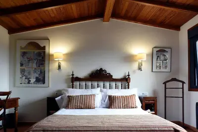 a bedroom with a large bed with two pillows at Casa de Afora Casa con piscina y jacuzzi privados in Santiago de Compostela