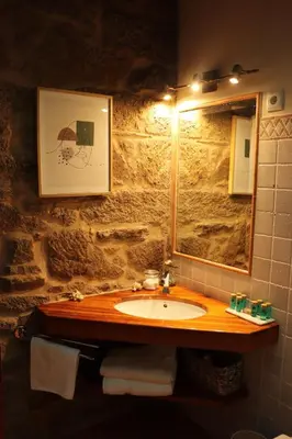 a bathroom with a sink and a mirror at Casa de Afora Casa con piscina y jacuzzi privados in Santiago de Compostela