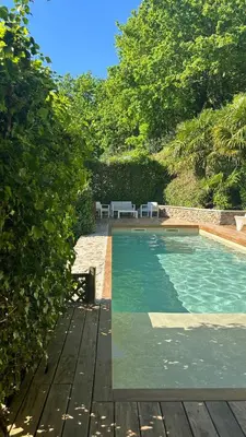 a swimming pool with a table and two white chairs at Casa de Afora Casa con piscina y jacuzzi privados in Santiago de Compostela