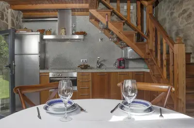 a kitchen with a table with two glasses on it at Casa de Afora Casa con piscina y jacuzzi privados in Santiago de Compostela