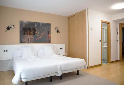 a bedroom with a large white bed with white pillows at Stellae Luscofusco in Santiago de Compostela