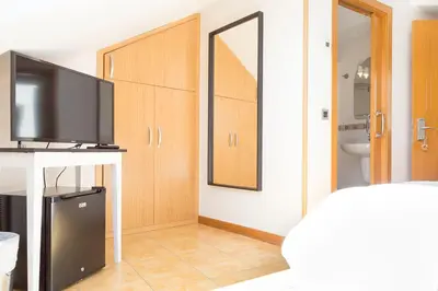 a living room with a television and a room with a mirror at Stellae Luscofusco in Santiago de Compostela
