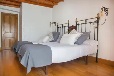 a bedroom with two large beds with blue and white pillows at Casa do Cruceiro in As Galanas