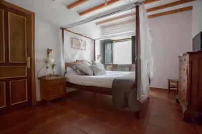 a bedroom with a canopy bed and a window at Casa do Cruceiro in As Galanas