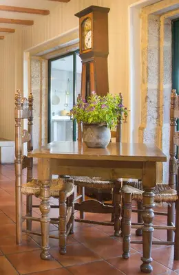 a table with a potted plant on it with a clock at Casa do Cruceiro in As Galanas
