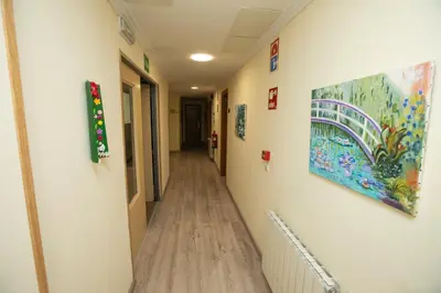 a hallway in a hospital with paintings on the walls at Hotel PAYRO in Santiago de Compostela