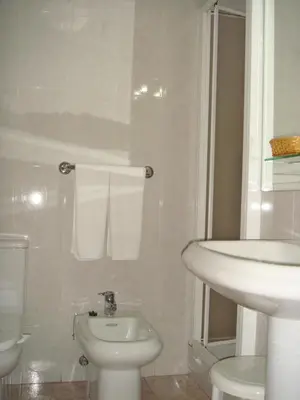 a white bathroom with a sink and a toilet at Hotel PAYRO in Santiago de Compostela