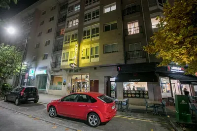a red car parked in front of a building at Hotel PAYRO in Santiago de Compostela