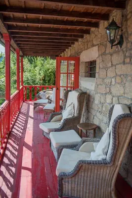 a row of chairs on a porch with a stone wall at Casa Grande de Rosende in Sober