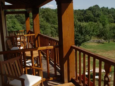 a porch with chairs and a view of the woods at Hotel Rural Aguallevada in Paramio