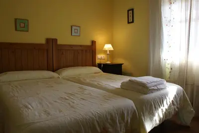a bedroom with a bed with white sheets and a window at Hotel Rural Aguallevada in Paramio