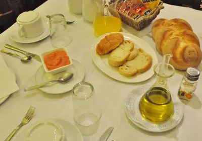 a white table topped with plates of food and bread at Hotel Rural Aguallevada in Paramio
