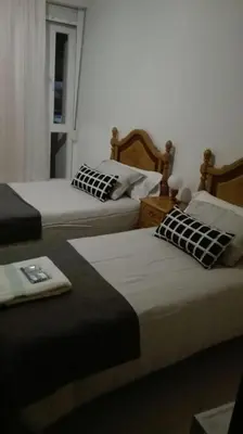 a room with two beds and a window at Apartamentos Loyo in Portomarin