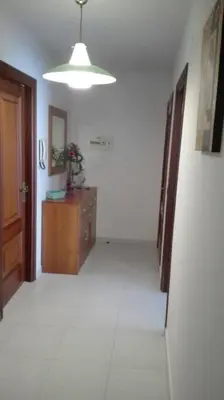 a hallway with a room with a door and a dresser at Apartamentos Loyo in Portomarin