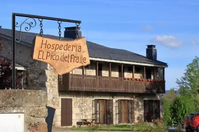 a sign in front of a house with a building at Hospedería El Pico del Fraile in Cobreros