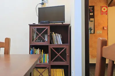 a book shelf with a television on top of it at Hospedería El Pico del Fraile in Cobreros