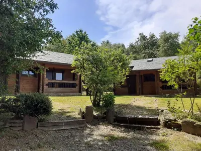 a log cabin with a tree in front of it at La Albarina in Galende
