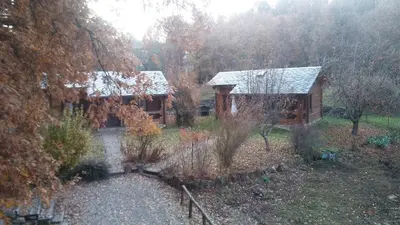 a cabin in the woods with snow on the roof at La Albarina in Galende