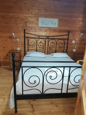 a black bed in a room with wooden walls at La Albarina in Galende