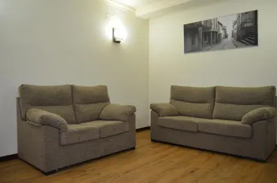two chairs in a living room with a picture on the wall at Albergue del Peregrino in Arzúa