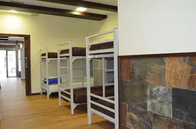 a room with three bunk beds and a wall at Albergue del Peregrino in Arzúa
