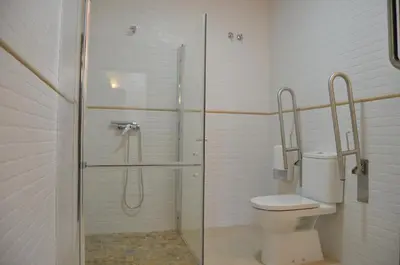a bathroom with a toilet and a glass shower at Albergue del Peregrino in Arzúa
