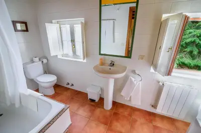 a white bathroom with a sink and a toilet at Hotel Rural La Casa del Burrero in Castropol