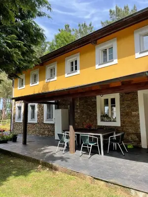 a house with a table and chairs in front of it at Hotel Rural La Casa del Burrero in Castropol