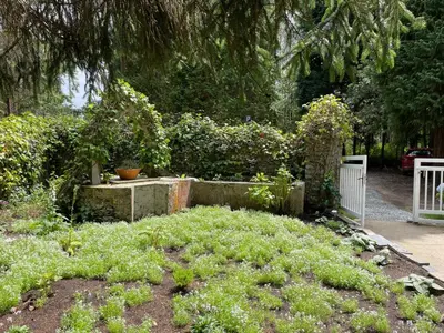a garden with a white fence and some plants at Hotel Rural La Casa del Burrero in Castropol