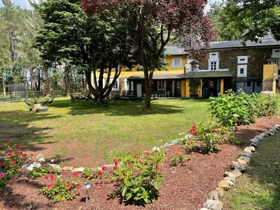 a garden with flowers in front of a house at Hotel Rural La Casa del Burrero in Castropol