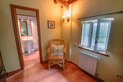 a bathroom with a wicker chair with a pillow in it at Hotel Rural La Casa del Burrero in Castropol